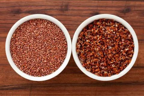 Två skålar med quinoa, en med råa röda frön och en med kokt, som visar dess höga quinoa protein.