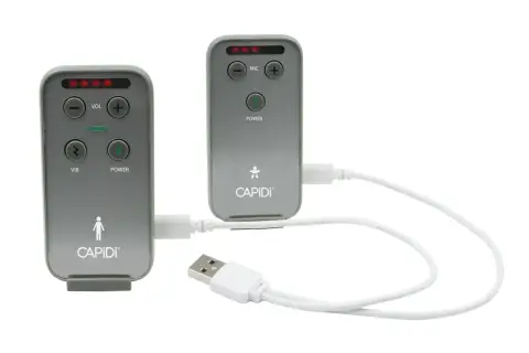 Två grå enheter med texten CAPIDI och knappar för volym, mikrofon, vibration och ström. En vit USB-kabel kopplar ihop dem. En trygghet med capidi babyalarm.